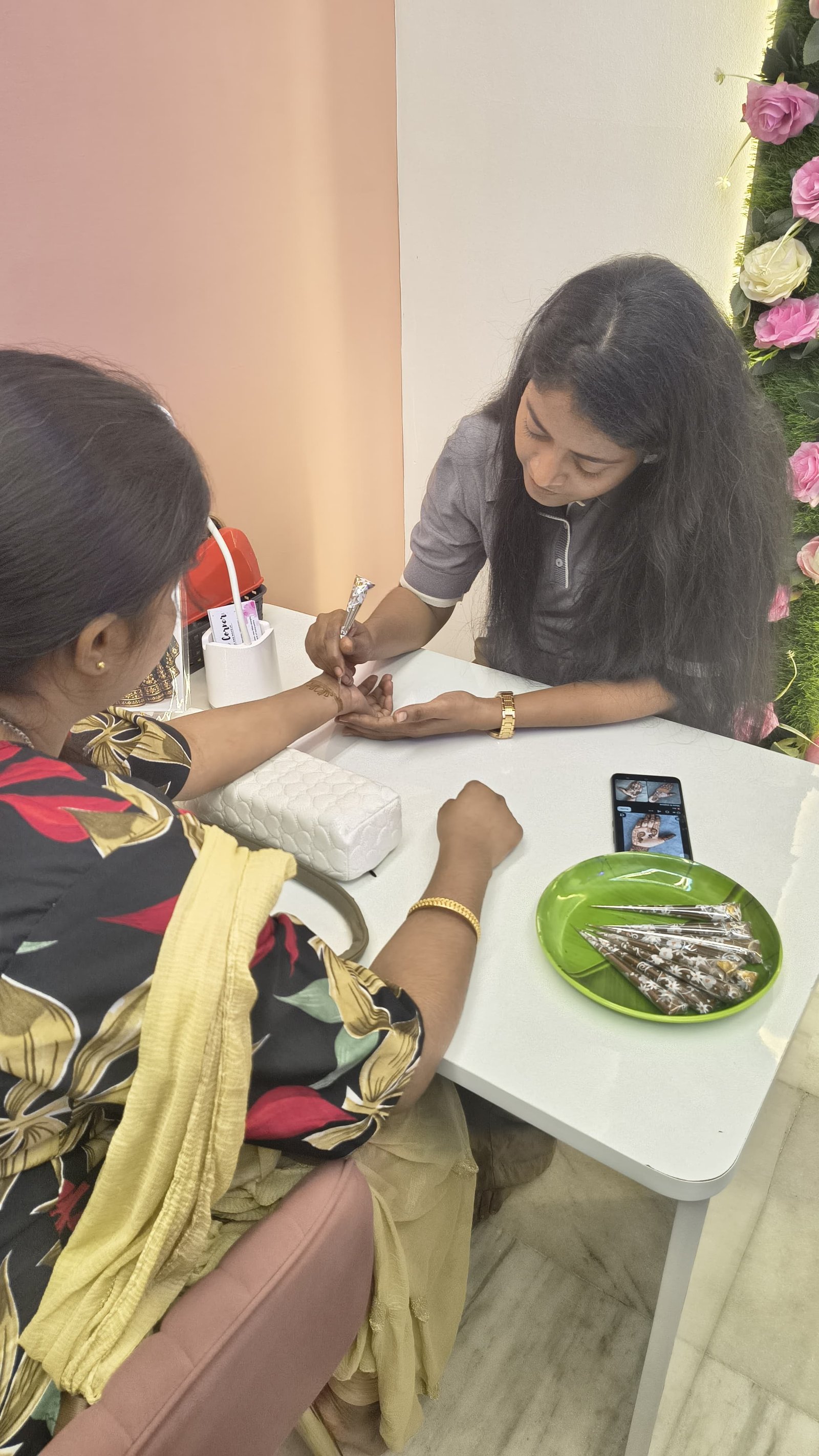 Mehendi artist applying design at Creative Corner