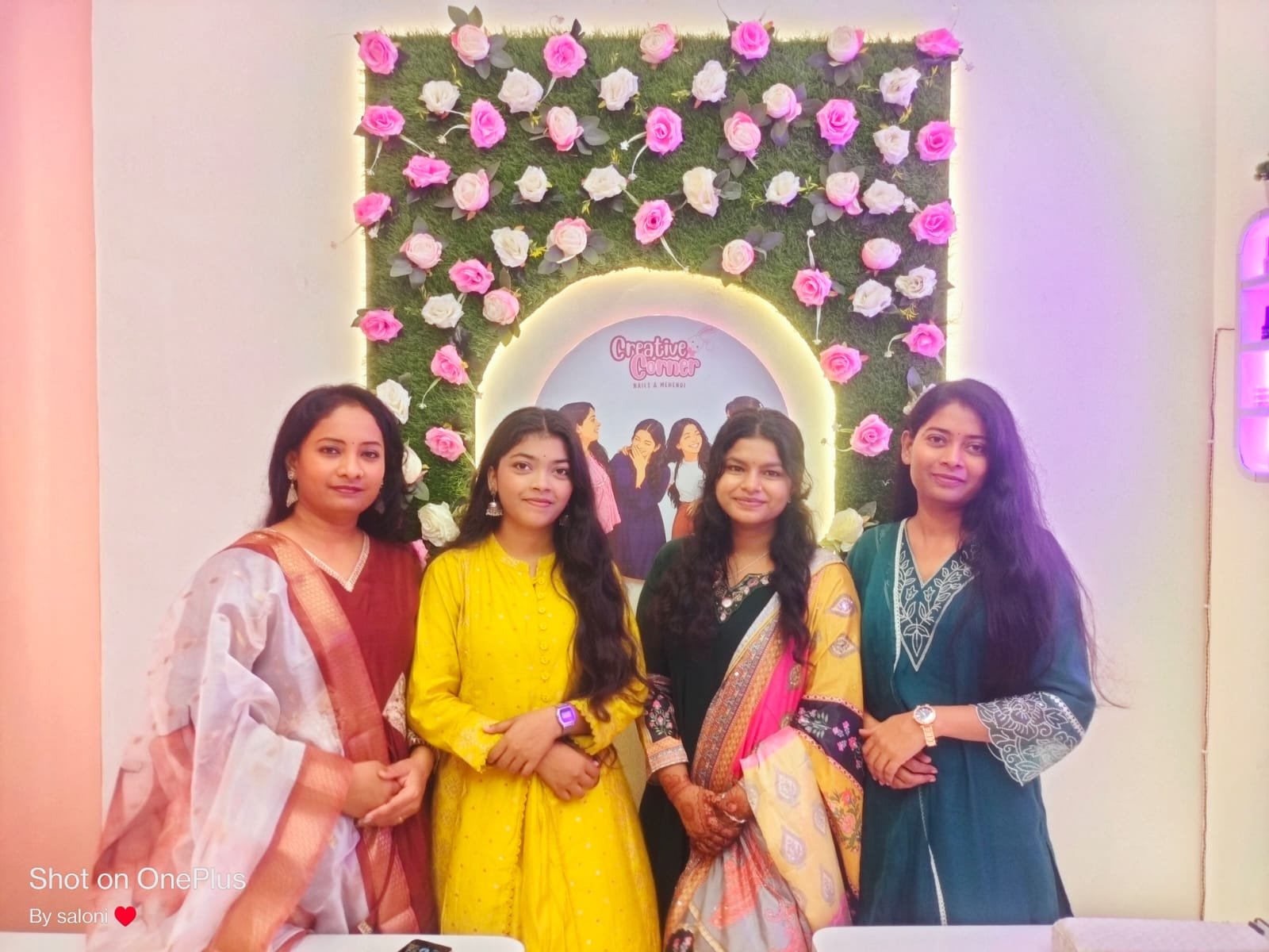 Creative Corner founding team in front of signature flower wall