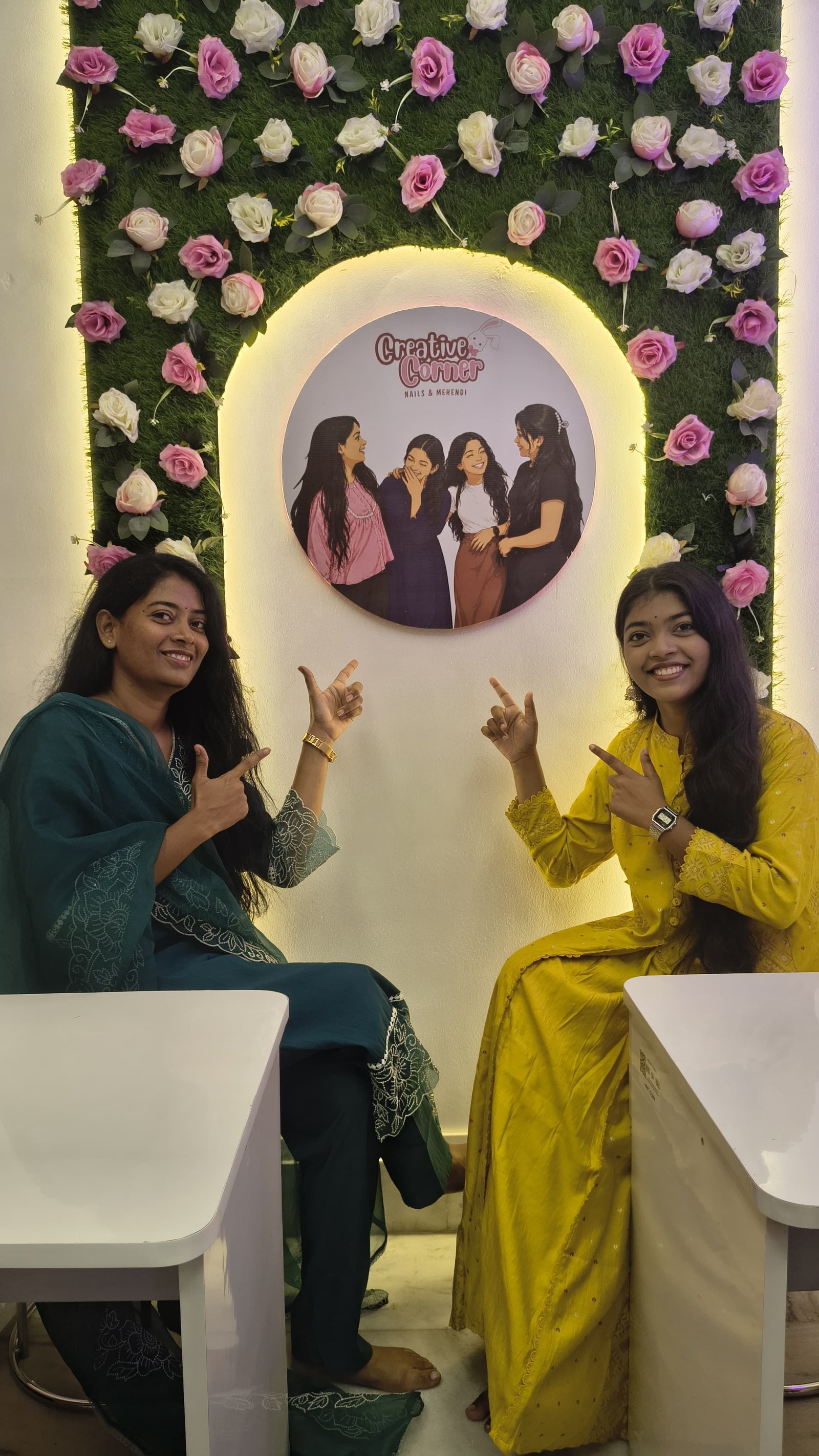 Creative Corner salon interior with nail stations and flower wall backdrop