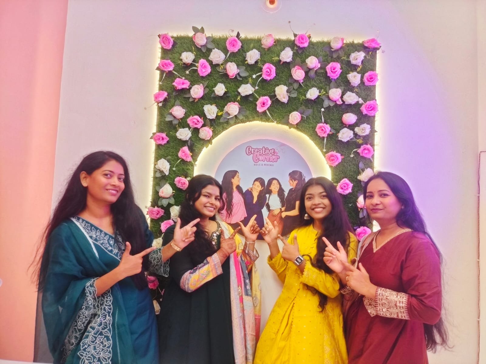 Team pointing at Creative Corner sign
